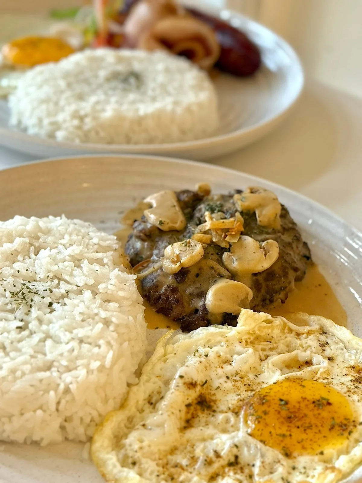 Mushroom-topped patties with rice and a fried egg